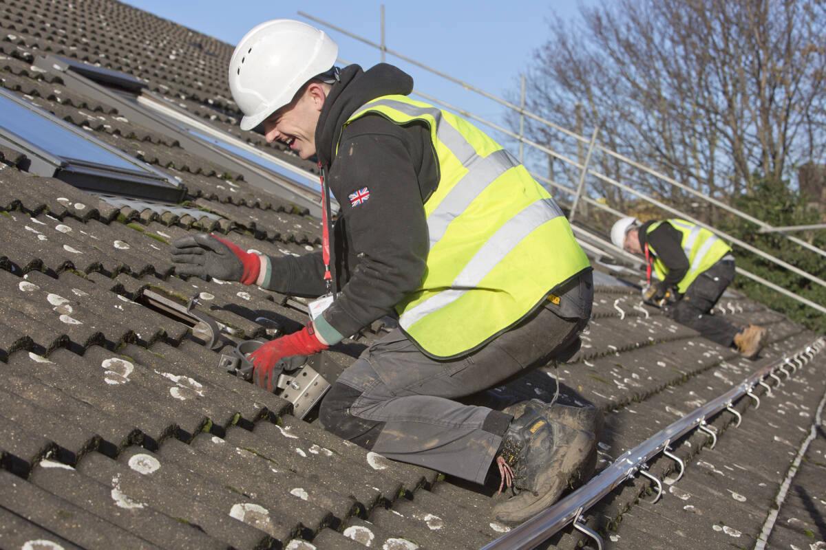 An image of a worker on the roof of Longfield House during Solar PV installation